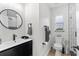 Modern bathroom with unique tile, floating vanity, round mirror, and a toilet at 4420 Pompano Se Dr, St Petersburg, FL 33705