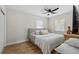 Bright bedroom featuring hardwood floors, fan, and two windows at 4420 Pompano Se Dr, St Petersburg, FL 33705