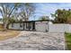 Charming single-story home with well-manicured lawn, gray paved driveway, and attached garage at 4420 Pompano Se Dr, St Petersburg, FL 33705