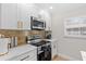 Close-up of kitchen featuring stainless steel appliances, gold accents, and white marble countertops at 4420 Pompano Se Dr, St Petersburg, FL 33705