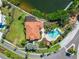 Aerial view of community pool and clubhouse overlooking lake at 861 Symphony Isles Blvd, Apollo Beach, FL 33572