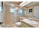 Bathroom with a sliding glass door shower, and a wide mirror above the sink, providing plenty of light at 861 Symphony Isles Blvd, Apollo Beach, FL 33572