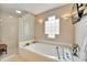 Bright bathroom with a modern tub, glass block accent wall, and stylish sconces at 861 Symphony Isles Blvd, Apollo Beach, FL 33572