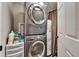 A laundry room with a stacked washer and dryer set and white water heater at 861 Symphony Isles Blvd, Apollo Beach, FL 33572