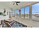 Bright sunroom featuring wall-to-wall windows with views of the canal and neighboring homes at 861 Symphony Isles Blvd, Apollo Beach, FL 33572
