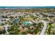 Community aerial view featuring pool, park, playground and residences, all surrounded by lush greenery and landscaping at 6834 Blue Moon Way, Sun City Center, FL 33573