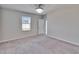 A bright, carpeted bedroom with a window and a ceiling fan, with a door to the en suite at 6834 Blue Moon Way, Sun City Center, FL 33573