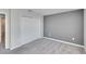 A carpeted bedroom features a closet with white doors and a gray accent wall at 6834 Blue Moon Way, Sun City Center, FL 33573