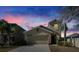 Charming home with a two-car garage, complimented by lush palm trees and twilight skies at 6834 Blue Moon Way, Sun City Center, FL 33573