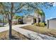 Inviting exterior of a tan two-story home, featuring an attached garage and well-maintained lawn on a sunny day at 6834 Blue Moon Way, Sun City Center, FL 33573