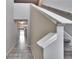 Bright hallway featuring tiled floors, a staircase with white railings, and neutral walls that guide to other rooms at 6834 Blue Moon Way, Sun City Center, FL 33573