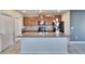 Kitchen island with granite countertops, stainless steel sink and faucet, black appliances, and wood finish cabinets at 6834 Blue Moon Way, Sun City Center, FL 33573