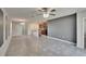 Spacious living room with tile flooring, ceiling fan, and view of the kitchen with an island at 6834 Blue Moon Way, Sun City Center, FL 33573
