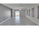 Spacious living room featuring tile flooring, neutral walls, a ceiling fan, and sliding glass doors for natural light at 6834 Blue Moon Way, Sun City Center, FL 33573