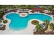 Expansive community pool with sun loungers, seating area, and tropical landscaping creates a resort-like atmosphere at 6834 Blue Moon Way, Sun City Center, FL 33573