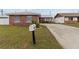 Charming brick home with a concrete driveway, mailbox, and well-manicured lawn and partial fencing at 6950 113Th St, Seminole, FL 33772