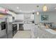 Stylish kitchen with stainless steel appliances, granite countertops, tiled backsplash, and a view of the living area at 6950 113Th St, Seminole, FL 33772