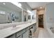 Bathroom features double sinks, large mirrors, a tiled floor and shower, plus a soaking tub at 302 Latitude Pl, Apollo Beach, FL 33572