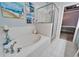 Bathroom features a soaking tub, tiled floors, glass enclosed shower, and peek into bedroom at 302 Latitude Pl, Apollo Beach, FL 33572