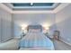 Bedroom features a tray ceiling, ceiling fan, queen bed, with accent furniture and an area rug at 302 Latitude Pl, Apollo Beach, FL 33572