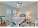 Cozy bedroom with a ceiling fan, shutters, wood floors, and an area rug at 302 Latitude Pl, Apollo Beach, FL 33572
