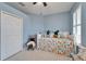 Bright bedroom features a vibrant patterned bedspread and light blue walls and carpet at 302 Latitude Pl, Apollo Beach, FL 33572