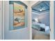 Bedroom view from hallway shows tray ceiling and beach themed decor, with a queen bed and accent furnishings at 302 Latitude Pl, Apollo Beach, FL 33572