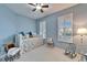 Bedroom with a daybed, blue walls, plantation shutters, and vintage decor at 302 Latitude Pl, Apollo Beach, FL 33572