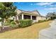 Charming home exterior with a screened porch, lush greenery, and a well-maintained lawn at 302 Latitude Pl, Apollo Beach, FL 33572
