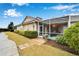 Rear exterior view of a home featuring a screened lanai, manicured lawn, and lush landscaping at 302 Latitude Pl, Apollo Beach, FL 33572