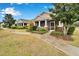 Home showcasing a beautifully landscaped front yard with a charming screened front porch at 302 Latitude Pl, Apollo Beach, FL 33572