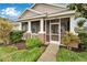 Charming home featuring a welcoming screened front porch and well-manicured landscaping at 302 Latitude Pl, Apollo Beach, FL 33572
