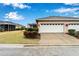 Property showcasing a two-car garage with a clean driveway and a well-maintained lawn at 302 Latitude Pl, Apollo Beach, FL 33572