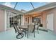 Enclosed patio with a large dining table, chairs, and a decorative chandelier, perfect for entertaining at 302 Latitude Pl, Apollo Beach, FL 33572