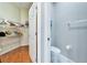 Bright powder room featuring a toilet and accessible storage space with wire shelving and wood flooring at 302 Latitude Pl, Apollo Beach, FL 33572