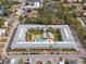 Detailed aerial shot of condo complex with manicured courtyard featuring a sparkling pool and neatly arranged parking at 4746 Azalea Dr # 105C, New Port Richey, FL 34652