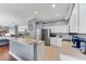 Open kitchen with breakfast bar, stainless appliances, white cabinets, tile floors, and living area access at 5608 Rockfield Loop, Valrico, FL 33596