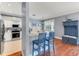 Open kitchen featuring white cabinets, stainless steel appliances, breakfast bar, and hardwood flooring at 5608 Rockfield Loop, Valrico, FL 33596