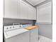 Functional laundry room featuring a washer, dryer, storage cabinets, and a window at 5608 Rockfield Loop, Valrico, FL 33596