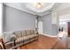 Cozy living area showcasing hardwood floors, stylish sofa, and an archway leading to another room at 5608 Rockfield Loop, Valrico, FL 33596