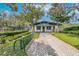 Exterior view of the tennis club with a paved walkway and manicured landscaping at 5608 Rockfield Loop, Valrico, FL 33596