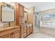 Elegant bathroom featuring dual sinks, a glass shower, and a soaking tub with natural light at 924 Landmark S Cir, Tierra Verde, FL 33715