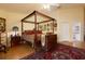 Bedroom with four-poster bed, wood floors and collection of wall art at 9341 Blind Pass Rd, St Pete Beach, FL 33706