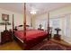 Bedroom with wood floors, four-poster bed, ceiling fan, and lots of natural light from the window at 9341 Blind Pass Rd, St Pete Beach, FL 33706