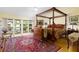 Primary bedroom with four-poster bed, balcony access, and area rug at 9341 Blind Pass Rd, St Pete Beach, FL 33706