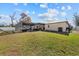 Spacious backyard featuring a screened lanai, lush lawn, and mature trees at 11001 Hobson St, Spring Hill, FL 34608