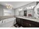 Bathroom featuring a jetted tub, double vanity, granite counters, and chandelier lighting at 11001 Hobson St, Spring Hill, FL 34608