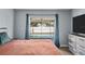 Comfortable bedroom with a view of the private backyard pool and access to the pool area at 11001 Hobson St, Spring Hill, FL 34608