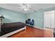 Bedroom featuring wood floors, light blue paneled walls, and gaming setup at 11001 Hobson St, Spring Hill, FL 34608