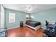 Bright bedroom with wood floors and comfortable bed and dual gaming chairs at 11001 Hobson St, Spring Hill, FL 34608